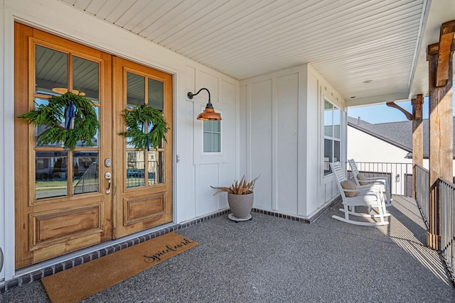 view of exterior entry featuring a porch and french doors