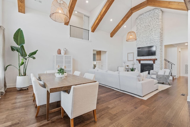 dining area featuring beamed ceiling, dark wood-type flooring, and high vaulted ceiling