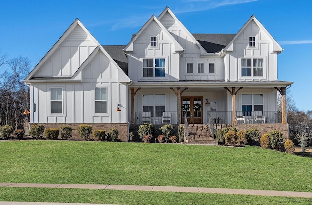 view of front of house featuring a front yard, french doors, and covered porch