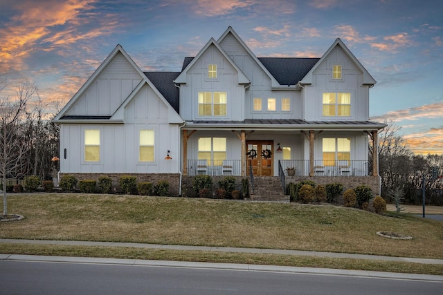 view of front of property featuring french doors, a yard, and covered porch