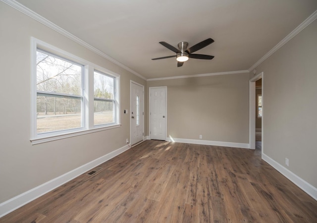 spare room featuring dark hardwood / wood-style flooring, ornamental molding, and ceiling fan