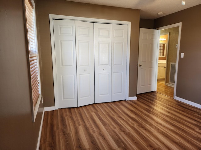 unfurnished bedroom featuring wood-type flooring and a closet