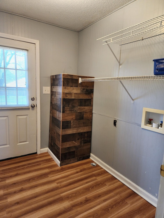 laundry room with washer hookup, wood-type flooring, and a textured ceiling