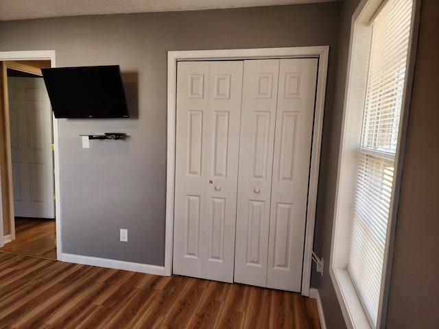 unfurnished bedroom featuring dark hardwood / wood-style flooring and a closet