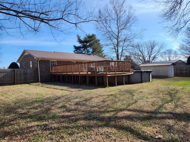 back of property featuring a storage unit, a pool side deck, and a lawn