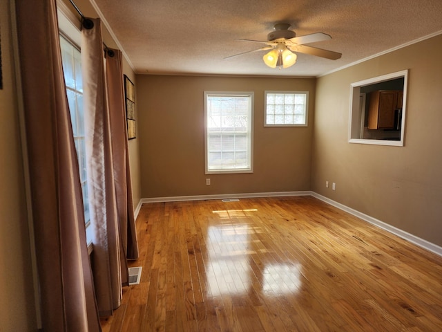 spare room with ceiling fan, crown molding, light hardwood / wood-style flooring, and a textured ceiling