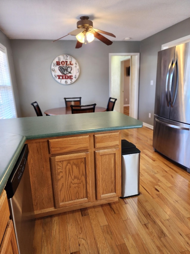 kitchen featuring ceiling fan, appliances with stainless steel finishes, and light hardwood / wood-style flooring