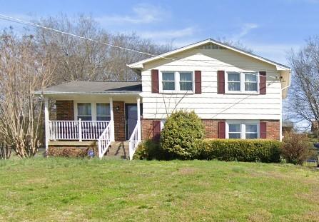 split level home with a porch and a front lawn