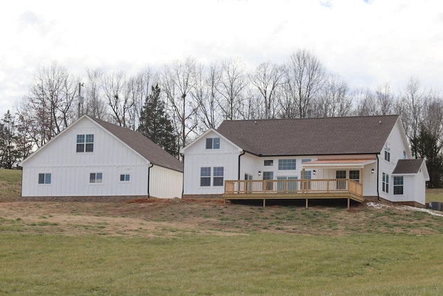 rear view of property with a yard and a deck