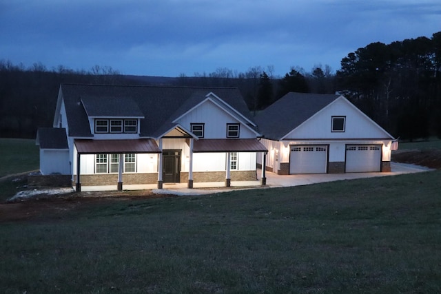 modern inspired farmhouse with a garage and a lawn