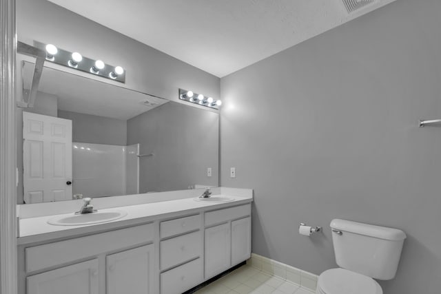 bathroom with walk in shower, tile patterned floors, vanity, and toilet