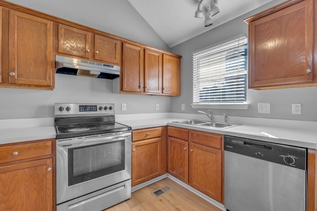 kitchen with stainless steel appliances, lofted ceiling, sink, and light wood-type flooring