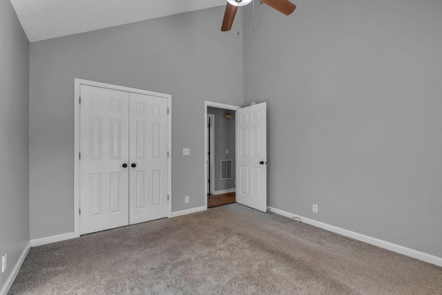 unfurnished bedroom featuring high vaulted ceiling, a closet, ceiling fan, and carpet flooring