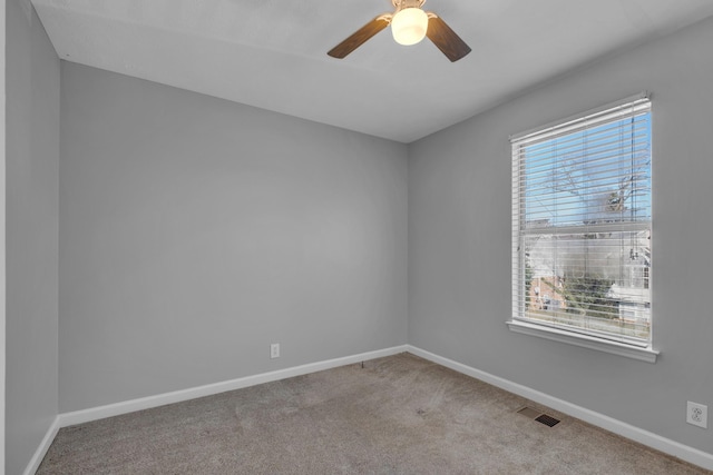 spare room featuring light colored carpet and ceiling fan