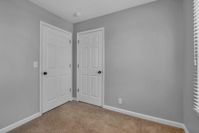 unfurnished bedroom with light colored carpet