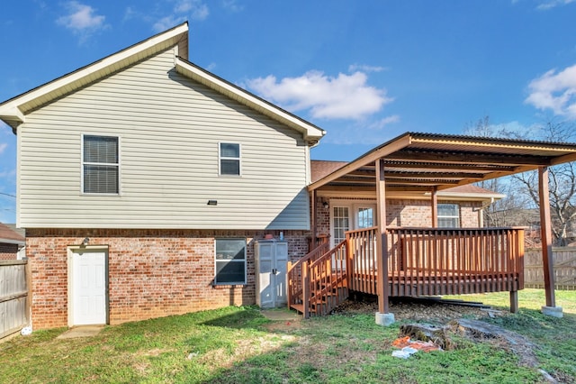 rear view of property with a deck and a lawn