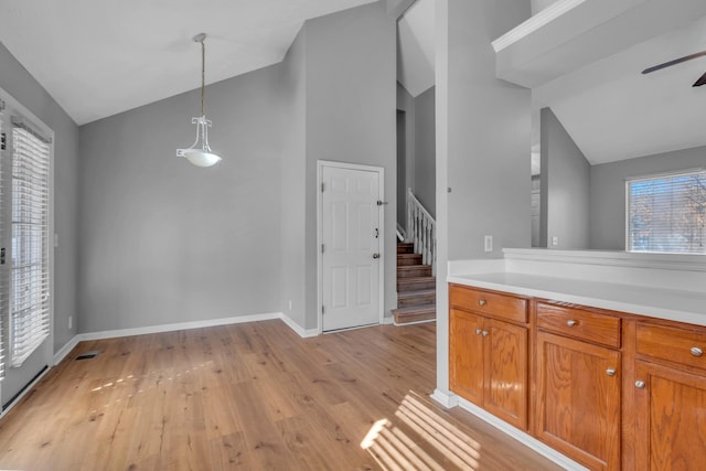 kitchen featuring pendant lighting, vaulted ceiling, ceiling fan, and light wood-type flooring