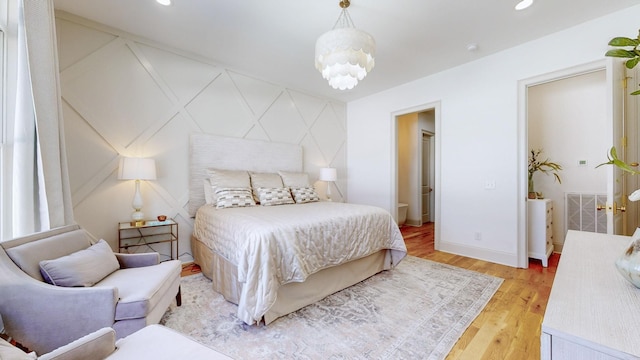 bedroom featuring a notable chandelier and light hardwood / wood-style floors