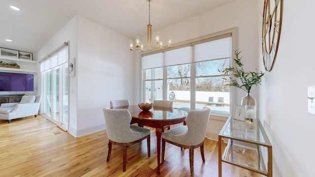 dining space with hardwood / wood-style flooring and a notable chandelier