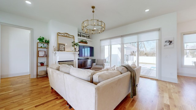 living room with light hardwood / wood-style floors and a notable chandelier