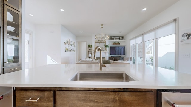 kitchen featuring hanging light fixtures, sink, and a center island with sink