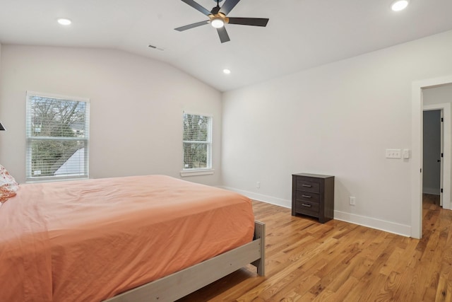 bedroom with lofted ceiling, multiple windows, light hardwood / wood-style floors, and ceiling fan