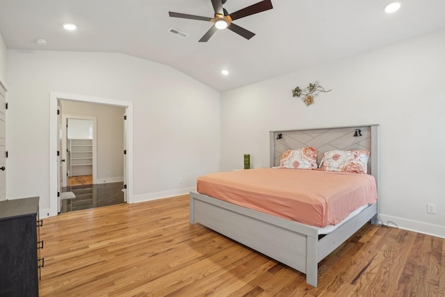 bedroom with vaulted ceiling, ceiling fan, and light wood-type flooring