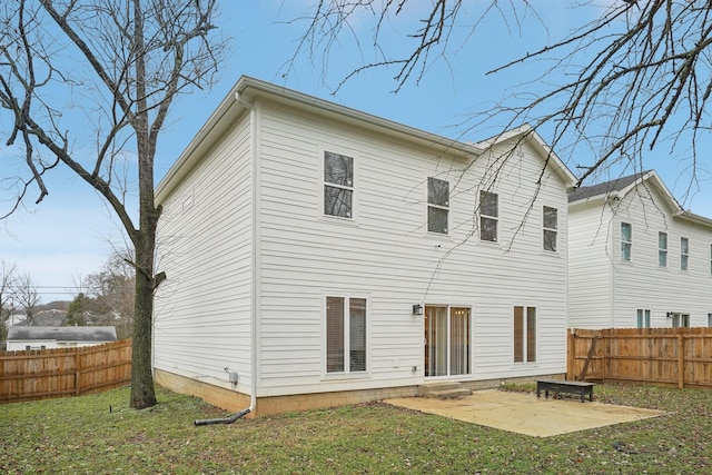 rear view of house featuring a patio area and a lawn