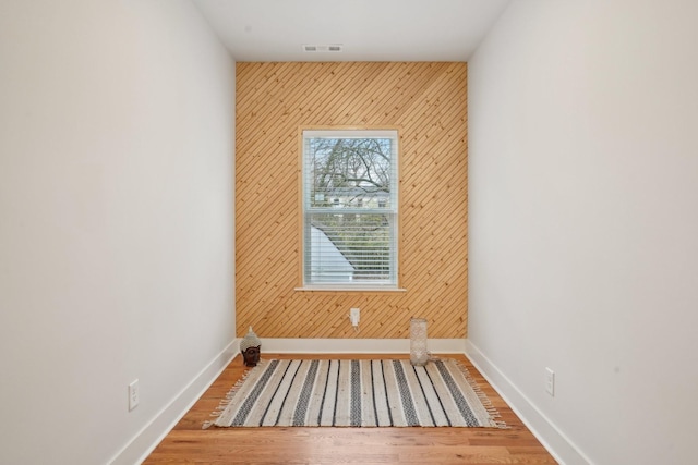 unfurnished room featuring hardwood / wood-style floors and wood walls