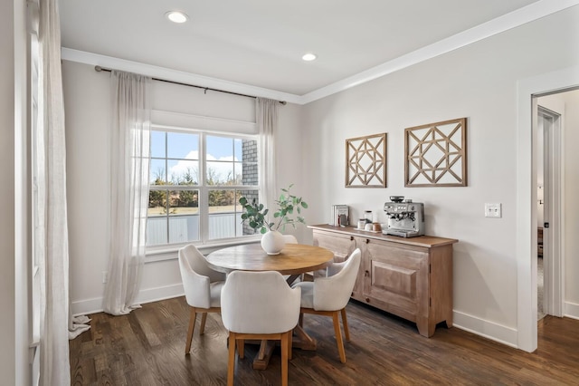 dining area with ornamental molding and dark hardwood / wood-style flooring