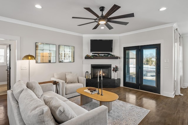 living room featuring ornamental molding, plenty of natural light, dark wood-type flooring, and ceiling fan