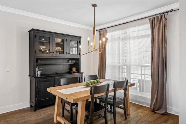 dining space featuring dark wood-type flooring, a healthy amount of sunlight, crown molding, and a notable chandelier