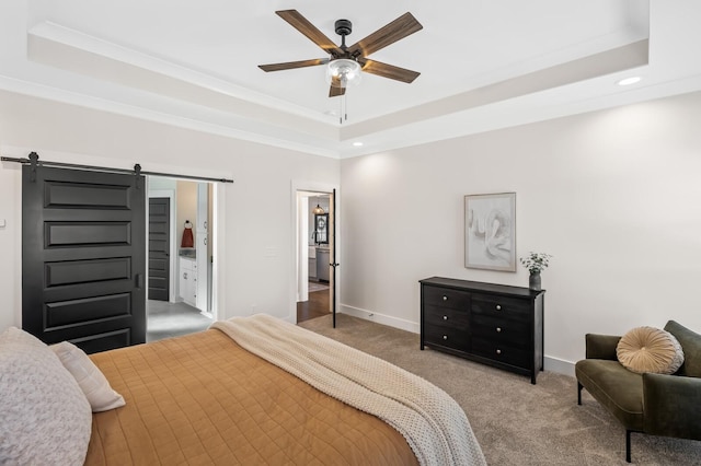 bedroom featuring crown molding, a tray ceiling, ceiling fan, a barn door, and carpet