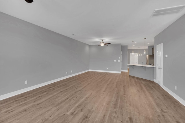 unfurnished living room with hardwood / wood-style floors and ceiling fan