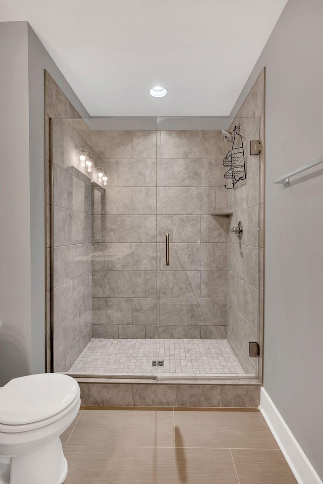 bathroom with an enclosed shower, tile patterned floors, and toilet