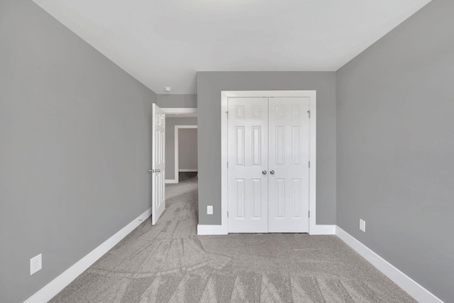 unfurnished bedroom featuring light carpet and a closet