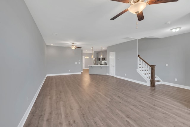 unfurnished living room featuring hardwood / wood-style flooring and ceiling fan