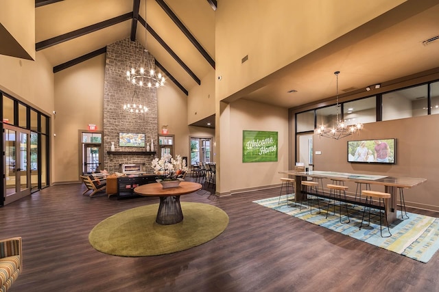 interior space with dark wood-type flooring, an inviting chandelier, high vaulted ceiling, a brick fireplace, and beamed ceiling