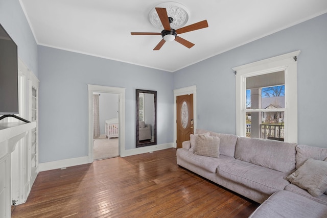 living room with crown molding, ceiling fan, and dark hardwood / wood-style floors