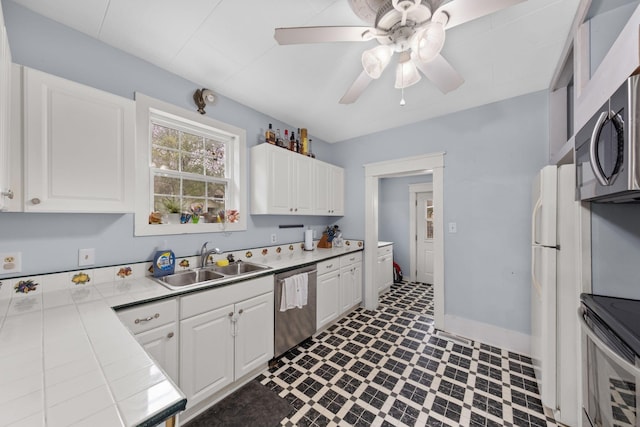 kitchen featuring white cabinetry, sink, tile countertops, and appliances with stainless steel finishes