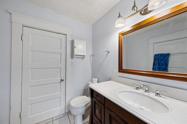 bathroom featuring vanity, toilet, tile patterned flooring, and a textured ceiling