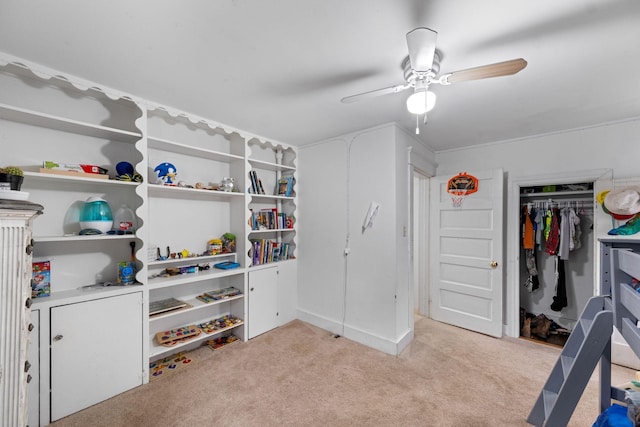 walk in closet with light colored carpet and ceiling fan