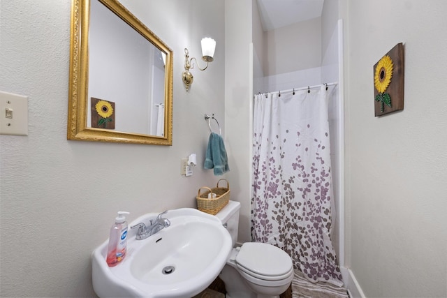 bathroom featuring sink, toilet, and walk in shower