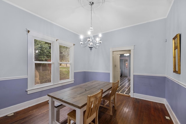 dining room with crown molding, dark hardwood / wood-style floors, and a chandelier