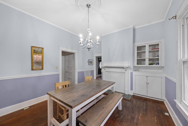 dining space with crown molding, dark hardwood / wood-style flooring, and a chandelier