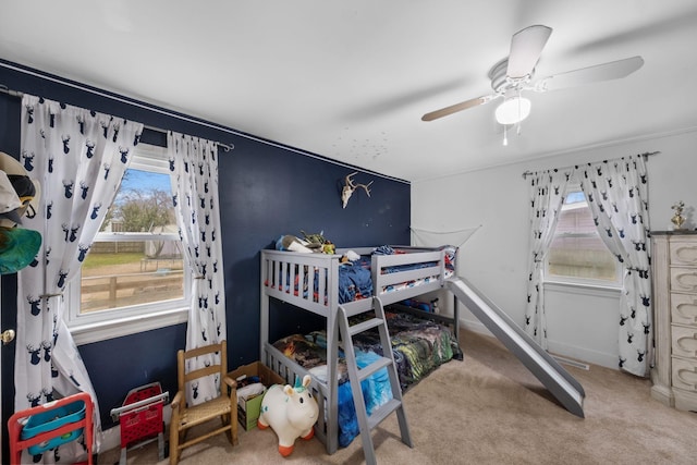 bedroom with multiple windows, ceiling fan, and carpet flooring