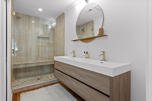 bathroom featuring hardwood / wood-style flooring, vanity, and a tile shower