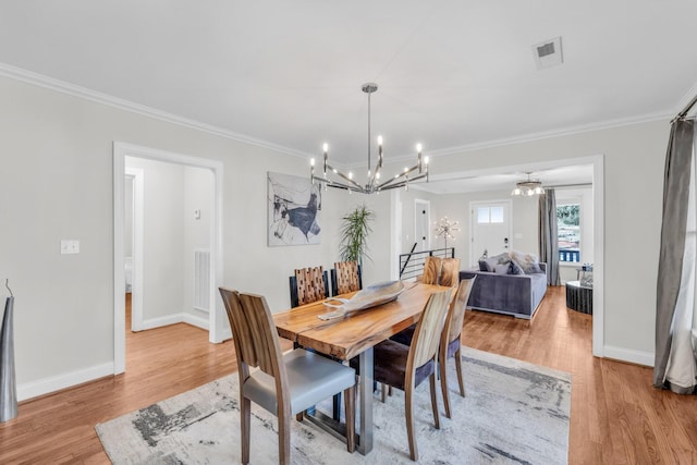 dining room with crown molding and light wood-type flooring