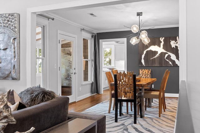 dining space featuring ornamental molding and light hardwood / wood-style floors