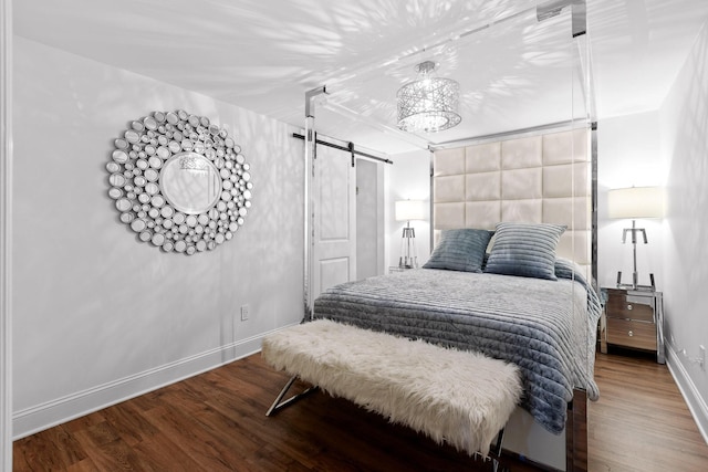 bedroom featuring a barn door and hardwood / wood-style floors